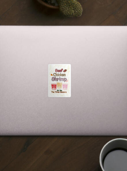 a white sticker on a laptop and on it, it says, "beef, chicken, shrimp ah yes the three genders." The tone is silly, and the colors of the cup of noodles and text are red, yellow, and pink, corresponding to ramen noodle packaging and flavor